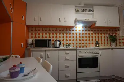 a kitchen with white cabinets and a table with a microwave at Seaview apartment in Piraeus