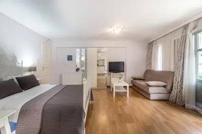 a bedroom with a bed and a couch and a television at UrbanStay in Athens