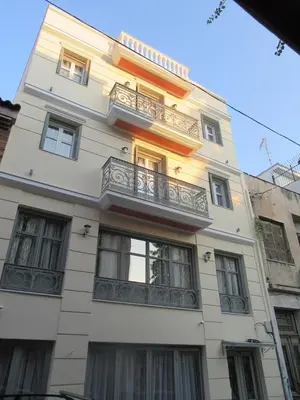 a tall white building with a balcony on it at UrbanStay in Athens