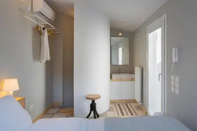 a bedroom with a bed and a bathroom with a sink at Auntie’s Home in Athens