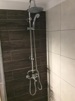 a shower in a bathroom with a shower head at Renovated apartment in Athens