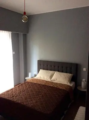 a bedroom with a bed and a blue wall at Renovated apartment in Athens