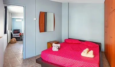 a red bed in a room with a mirror at Loft in Athens