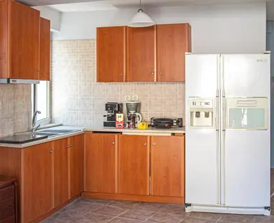 a kitchen with wooden cabinets and a white refrigerator at Loft in Athens
