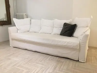 a white couch with a black pillow on it at The Best Spot in The Center in Athens