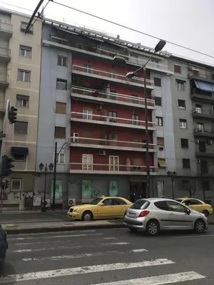 two cars parked in front of a large building at The Best Spot in The Center in Athens