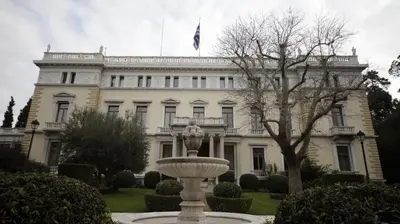 a white building with a fountain in front of it at The Best Spot in The Center in Athens