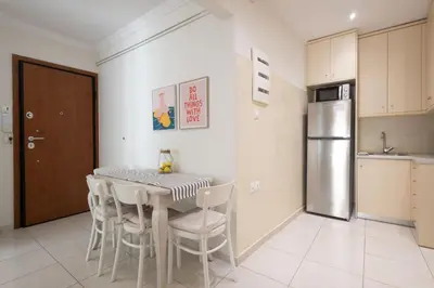 a kitchen with a table and chairs and a refrigerator at Meros - Athenian Residencies in Athens