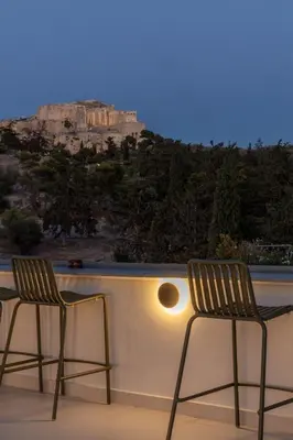 two chairs sitting on top of a balcony with a mountain at Meros - Athenian Residencies in Athens