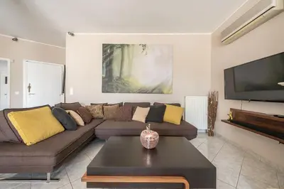 a living room with a couch and a tv at Athens View in Athens