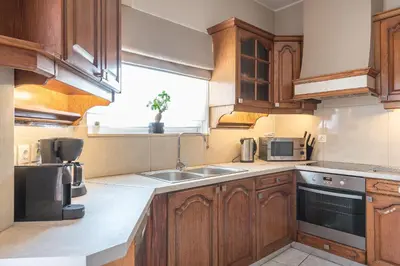 a kitchen with wooden cabinets and a sink and a window at Athens View in Athens