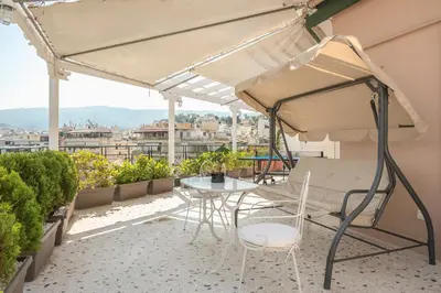 a patio with a table and chairs on a balcony at Athens View in Athens