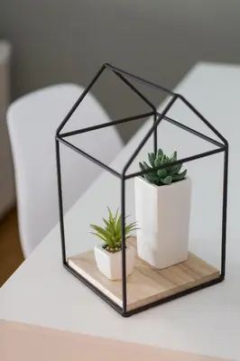 a glass cube with two plants on a table at Sleek Flat in Central Syntagma by UPSTREET in Athens