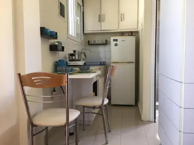 a kitchen with two chairs and a white refrigerator at For Harbor Travelers in Piraeus