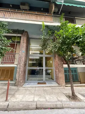 a building with a glass door with a tree in front at For Harbor Travelers in Piraeus