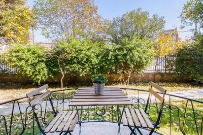 a wooden table with two chairs and a potted plant at Trendy Minimal Flat in posh Athens in Athens