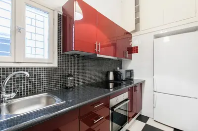 a kitchen with red cabinets and a sink at Trendy Minimal Flat in posh Athens in Athens