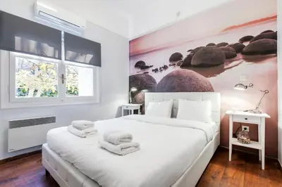 a bedroom with a white bed with towels on it at Trendy Minimal Flat in posh Athens in Athens