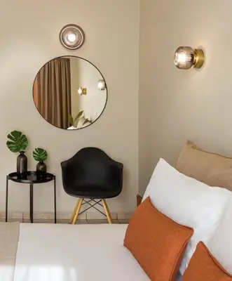 a bedroom with a black chair and a mirror at Hotel Delfini in Piraeus