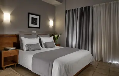 a bedroom with a large bed with white sheets and pillows at Hotel Delfini in Piraeus