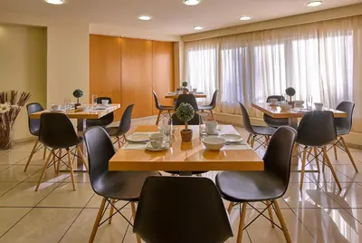 a conference room with tables and chairs in a room at Hotel Delfini in Piraeus