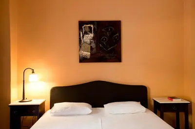 a bedroom with a bed with two tables and a picture on the wall at Elizabeth Hotel in Athens