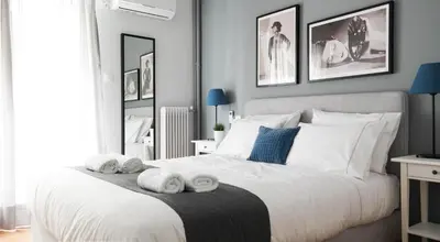 a bedroom with a white bed with towels on it at Modern Downtown Flat near the Acropolis by UPSTREET in Athens