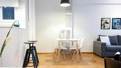 a living room with a table and chairs and a couch at Modern Downtown Flat near the Acropolis by UPSTREET in Athens
