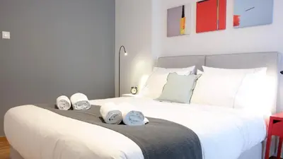 a bedroom with a large white bed with shoes on it at Modern Downtown Flat near the Acropolis by UPSTREET in Athens