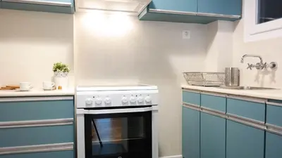 a kitchen with a white stove and blue cabinets at Modern Downtown Flat near the Acropolis by UPSTREET in Athens