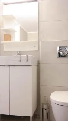 a white bathroom with a sink and a toilet at Modern Downtown Flat near the Acropolis by UPSTREET in Athens