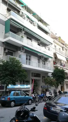 a parking lot with cars parked in front of a building at Modern Downtown Flat near the Acropolis by UPSTREET in Athens