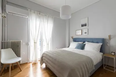 a bedroom with a bed and a chair and a window at Modern Flat next to the USA Embassy by UPSTREET in Athens