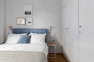 a bed with a blue headboard in a bedroom at Modern Flat next to the USA Embassy by UPSTREET in Athens