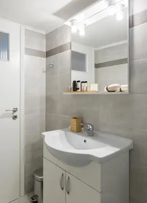 a bathroom with a white sink and a mirror at Modern Flat next to the USA Embassy by UPSTREET in Athens