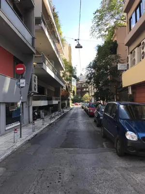an empty street with cars parked on the sides of buildings at Modern Flat next to the USA Embassy by UPSTREET in Athens