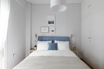 a bedroom with a bed with a blue headboard at Modern Flat next to the USA Embassy by UPSTREET in Athens