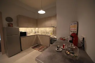 a kitchen with wooden cabinets and a counter top at Ports Crossroad B in Piraeus