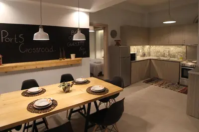 a kitchen and dining room with a wooden table and chairs at Ports Crossroad B in Piraeus