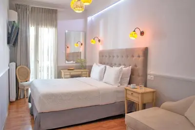 a bedroom with a large bed and a couch at Acropolis Ami Boutique Hotel in Athens