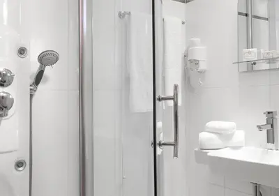 a white bathroom with a shower and a sink at Acropolis Ami Boutique Hotel in Athens