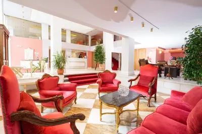 a living room with red chairs and a table at Acropolis Ami Boutique Hotel in Athens