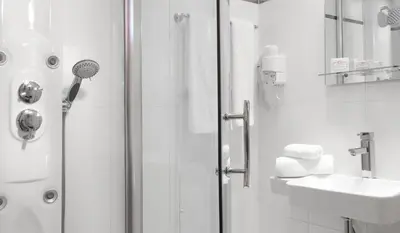 a white bathroom with a shower and a sink at Acropolis Ami Boutique Hotel in Athens