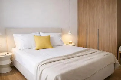 a bedroom with a white bed with a yellow pillow at Elegant Plaka Retreat by Liberty's Canvas in Athens