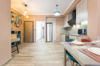 a kitchen with a counter and a table with chairs at Stylish Luxury Apartment near Acropolis at Neos Kosmos metro station in Athens