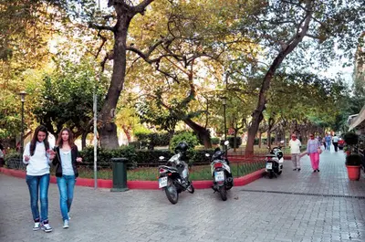 two women standing next to two motorcycles in a park at Menta errathens Apartment - Athens Center, 5 BD, 2 BATH in Athens