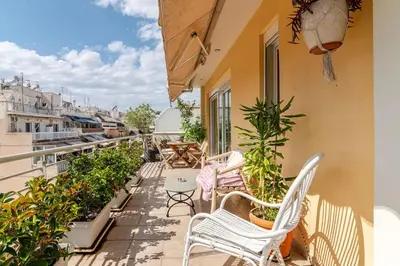 a balcony with chairs and tables and plants at Skyview Penthouse / Central Athens in Athens