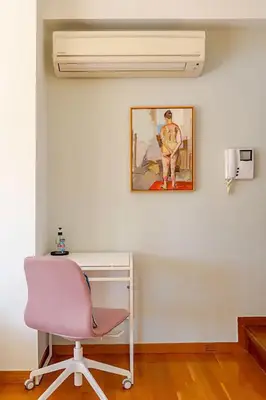 a pink chair sitting next to a desk with a picture at Skyview Penthouse / Central Athens in Athens