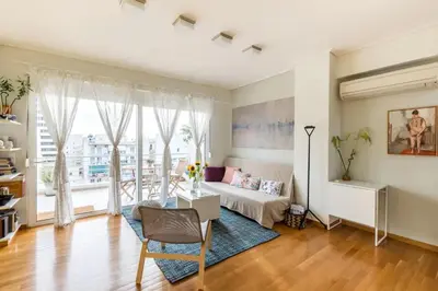 a living room with a bed and a large window at Skyview Penthouse / Central Athens in Athens