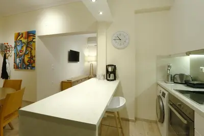 a kitchen with a counter and a clock on the wall at Charming City Centre Flat Kolonaki in Athens